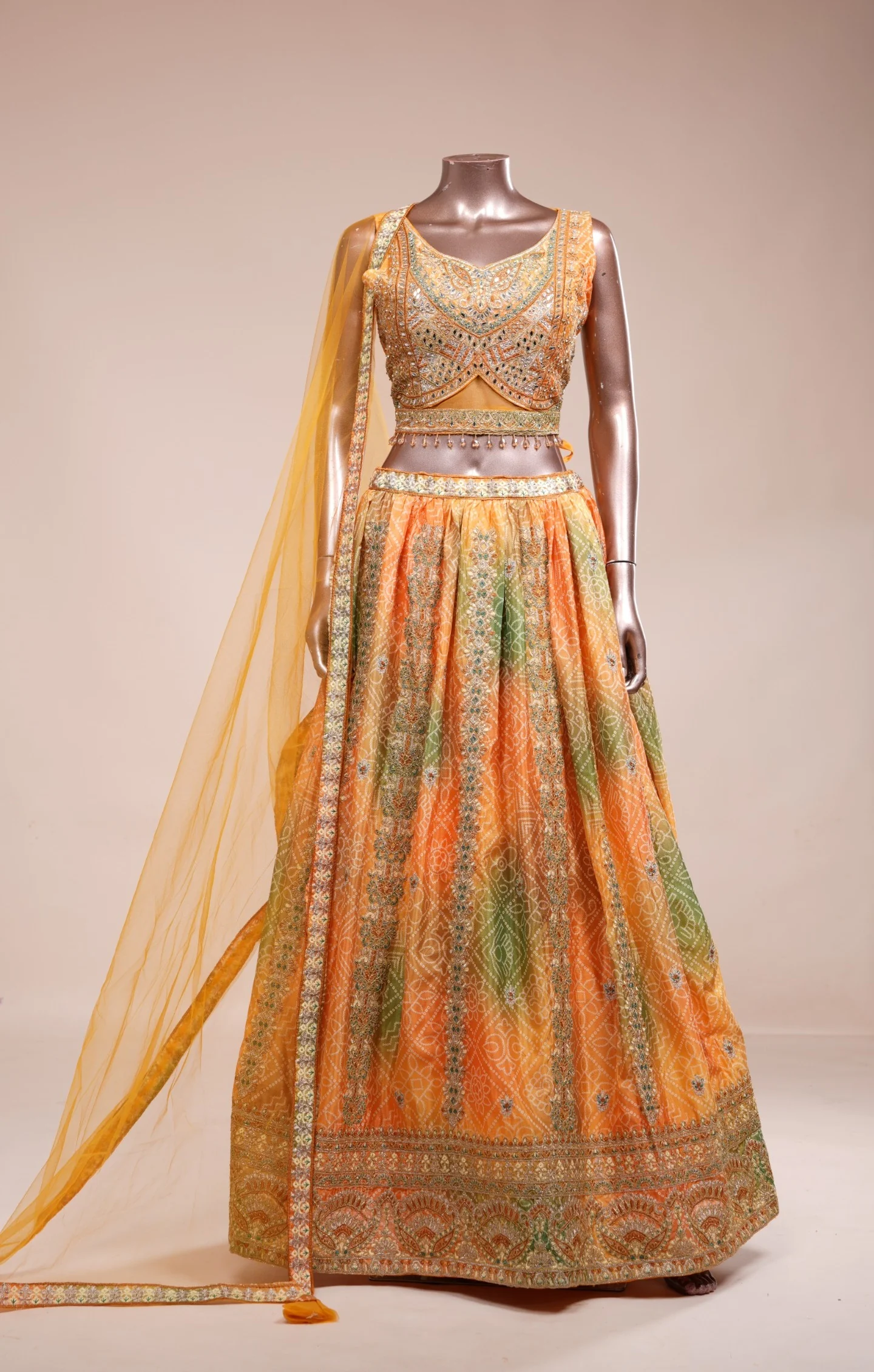 Orange and green embroidered lehenga displayed on a mannequin used as input for AI-powered virtual try-on.
